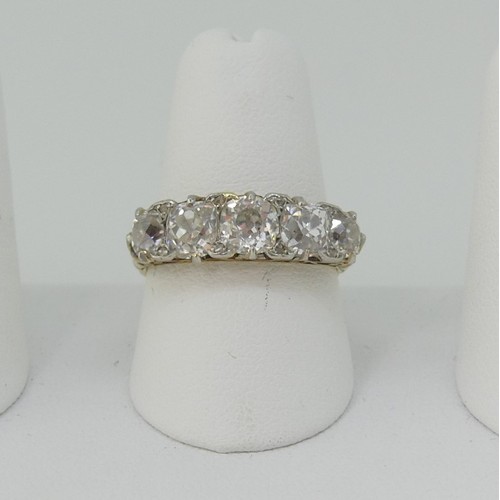 A graduated five stone diamond Ring, the old cut stones claw set in a carved gallery, the shank marked 18c, the centre stone approx. 0.6ct, total diamond weight approx 2.2ct, Size O, approx total weight 4.7g.