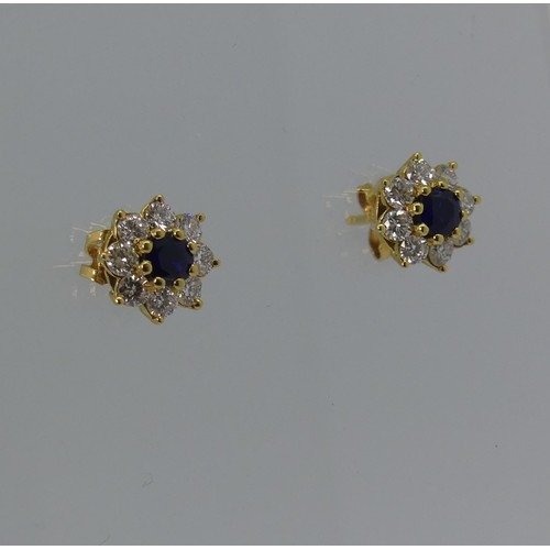 A pair of sapphire and diamond cluster Earrings, the central circular sapphires approx 3.7mm diameter, surrounded by eight brilliant cut diamonds, all mounted in 18ct gold, hallmarked on the pillar, approx total weight 3.5g.