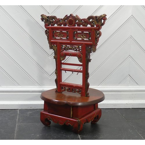 156 - A Chinese red and gold lacquer foot binding stool, decorated and carved with two dragons at the top,... 