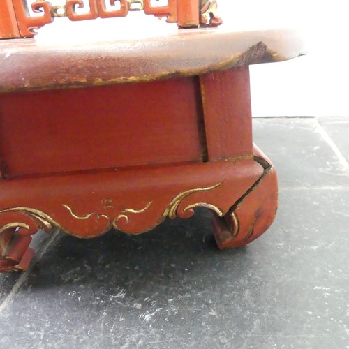 156 - A Chinese red and gold lacquer foot binding stool, decorated and carved with two dragons at the top,... 