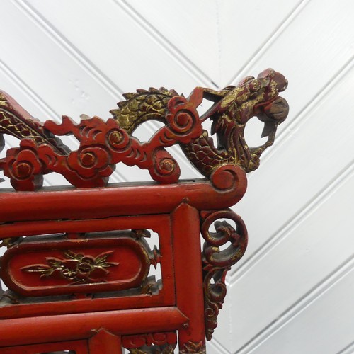 156 - A Chinese red and gold lacquer foot binding stool, decorated and carved with two dragons at the top,... 