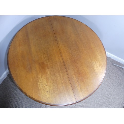 313 - A mid 20thC teak extending Dining Table, of circular form, raised on tapering legs, some scuffs and ... 