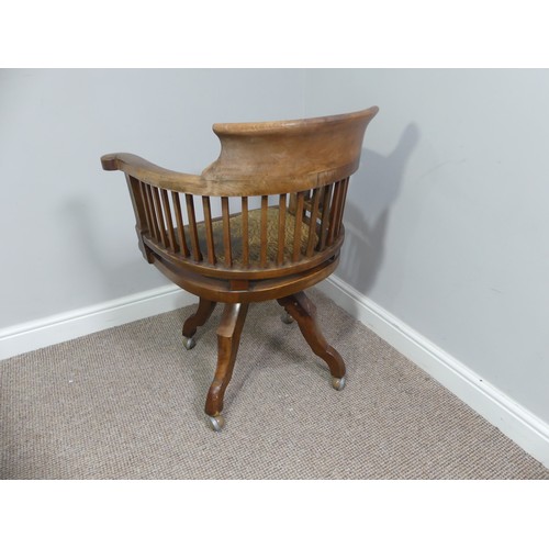 316 - An early 20thC swivel Desk Chair, with spindle back and scroll arms, above an upholstered pad seat, ... 