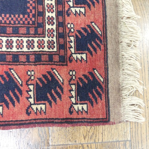 482 - Tribal rugs; an Afghan Rug, hand-knotted with geometric designs on a red ground, 100% wool, in fair ... 