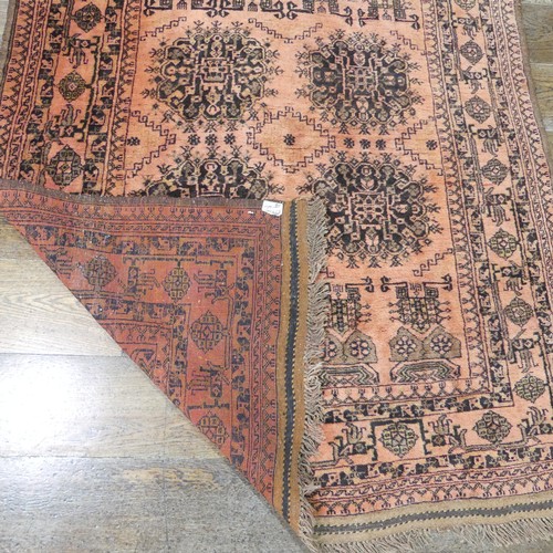 483 - Tribal rugs; an Afghan Rug, hand-knotted with tekke and geometric designs on a light red ground, 100... 