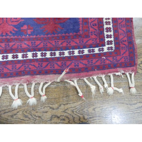 484 - Tribal rugs; an Afghan Rug, hand-knotted with geometric designs on a red ground, 100% wool, in fair ... 