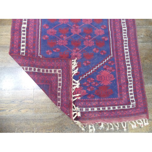 484 - Tribal rugs; an Afghan Rug, hand-knotted with geometric designs on a red ground, 100% wool, in fair ... 