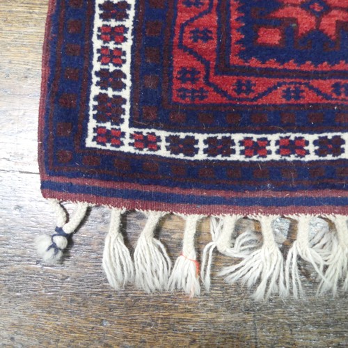 484 - Tribal rugs; an Afghan Rug, hand-knotted with geometric designs on a red ground, 100% wool, in fair ... 