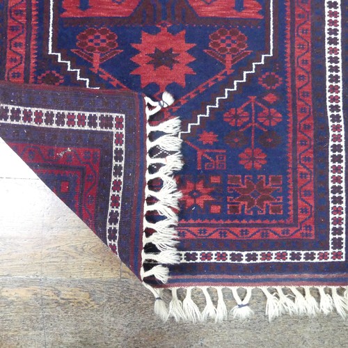 484 - Tribal rugs; an Afghan Rug, hand-knotted with geometric designs on a red ground, 100% wool, in fair ... 