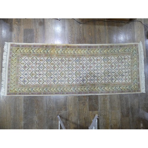 485 - Tribal rugs; a hand-knotted runner, cream ground woven with geometric designs, thick wool pile on co... 