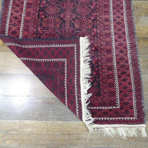 486 - Tribal rugs; an Afghan Rug, hand-knotted with geometric designs on a red ground, 100% wool, fringe w... 