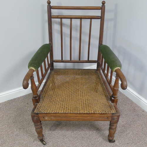 332 - A Victorian pitch pine framed Armchair, with stick back and scroll arms, upholstered green armrests,... 