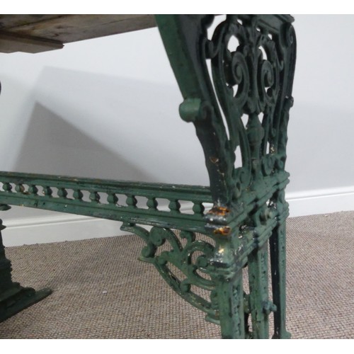 495 - Garden Furniture; a vintage green-painted cast iron Garden Table, the rectangular plank top, above a... 