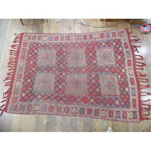 489 - Tribal Rugs; an Afghan rug, tekke on a red ground, 100% wool, fringes worn, 155cm x 183cm, together ... 