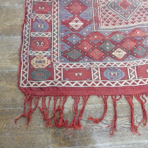 489 - Tribal Rugs; an Afghan rug, tekke on a red ground, 100% wool, fringes worn, 155cm x 183cm, together ... 