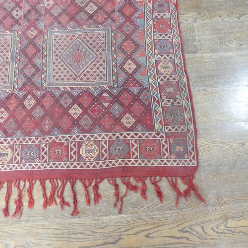 489 - Tribal Rugs; an Afghan rug, tekke on a red ground, 100% wool, fringes worn, 155cm x 183cm, together ... 