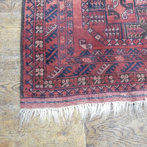 489 - Tribal Rugs; an Afghan rug, tekke on a red ground, 100% wool, fringes worn, 155cm x 183cm, together ... 