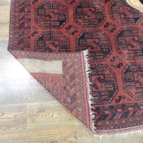 489 - Tribal Rugs; an Afghan rug, tekke on a red ground, 100% wool, fringes worn, 155cm x 183cm, together ... 