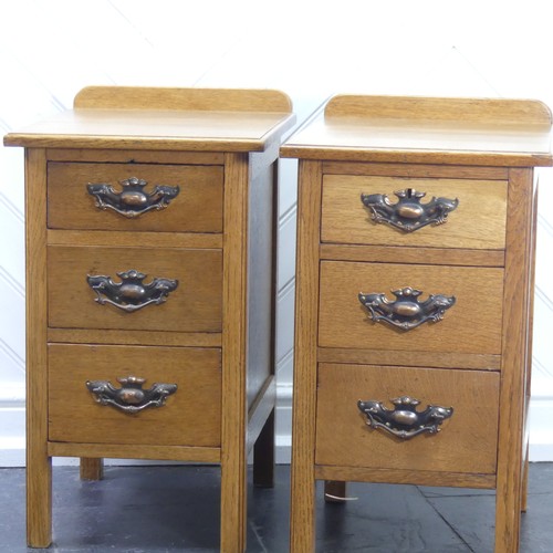 391 - A pair of Arts & Crafts light oak three-drawer Bedside Cabinets, fitted with later embossed bras... 