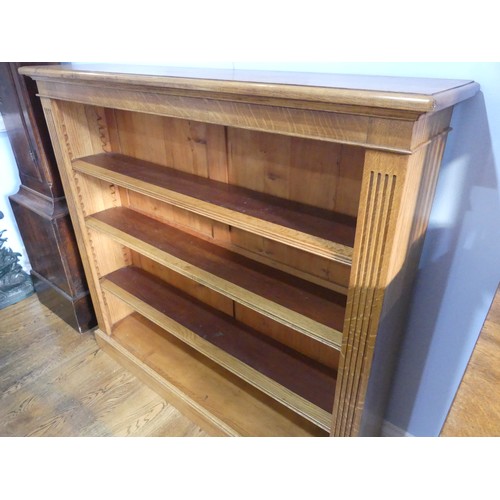 396 - An Edwardian light oak open Bookcase, with three adjustable shelves flanked by pilasters on plinth b... 