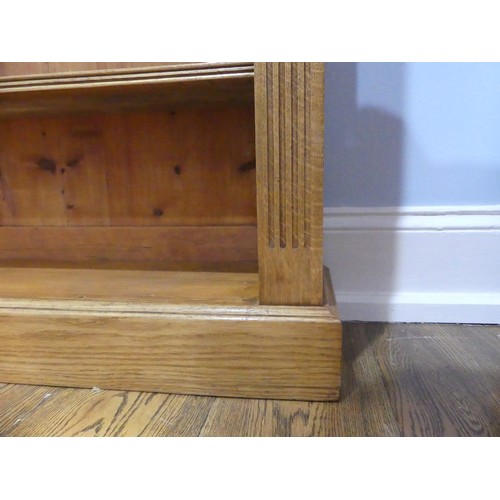 396 - An Edwardian light oak open Bookcase, with three adjustable shelves flanked by pilasters on plinth b... 