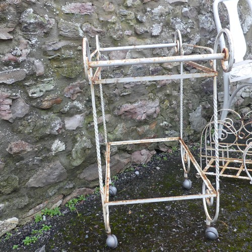 500 - Garden; a white scrollwork metal coffee table frame, lacks top, together with a trolley, rack and sh... 