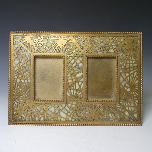 Tiffany Studios; a gilt bronze twin photograph Frame, in the 'pine needle' pattern with favrile glass panels in yellow/white/orange tones, marked 'Tiffany Studios New York 955', c1910, each aperture 5.5cm x 8.5cm, overall 26cm wide.