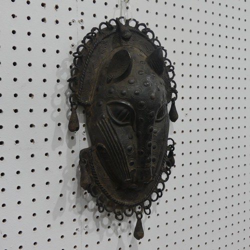 176 - Tribal art; a Benin bronze leopard mask with punched and raised decoration, edged with ring loops an... 