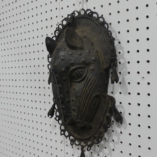 176 - Tribal art; a Benin bronze leopard mask with punched and raised decoration, edged with ring loops an... 