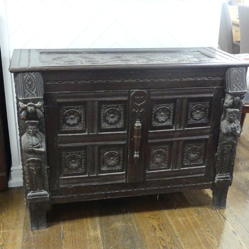 467 - An antique carved oak Cupboard, the front with two panelled doors and caryatid pilasters, both side ... 