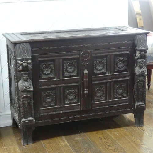 467 - An antique carved oak Cupboard, the front with two panelled doors and caryatid pilasters, both side ... 