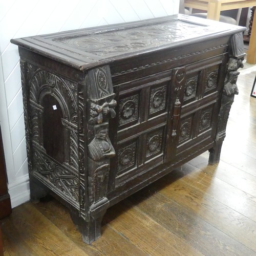 467 - An antique carved oak Cupboard, the front with two panelled doors and caryatid pilasters, both side ... 