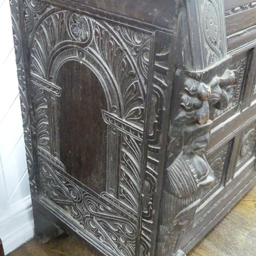 467 - An antique carved oak Cupboard, the front with two panelled doors and caryatid pilasters, both side ... 