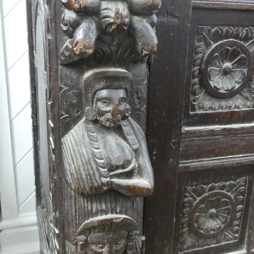 467 - An antique carved oak Cupboard, the front with two panelled doors and caryatid pilasters, both side ... 