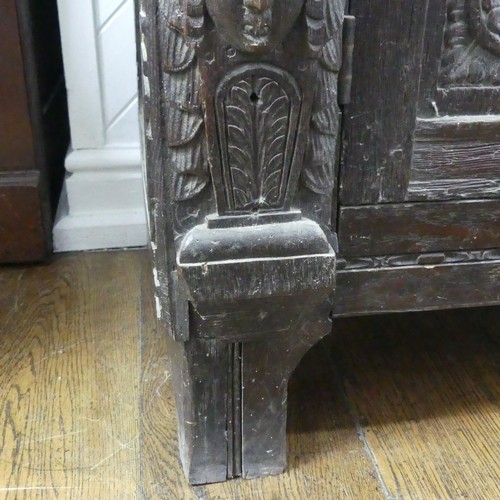 467 - An antique carved oak Cupboard, the front with two panelled doors and caryatid pilasters, both side ... 