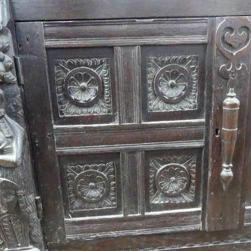 467 - An antique carved oak Cupboard, the front with two panelled doors and caryatid pilasters, both side ... 