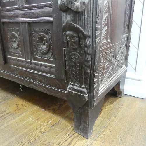 467 - An antique carved oak Cupboard, the front with two panelled doors and caryatid pilasters, both side ... 