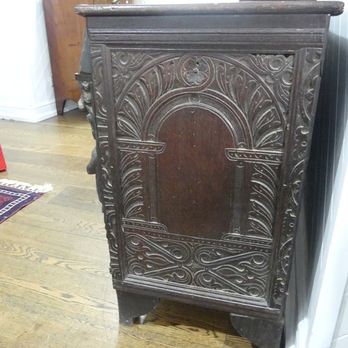 467 - An antique carved oak Cupboard, the front with two panelled doors and caryatid pilasters, both side ... 