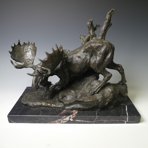 174 - A bronze sculpture of a Moose, modelled walking over rocky terrain, raised on a veined marble base, ... 