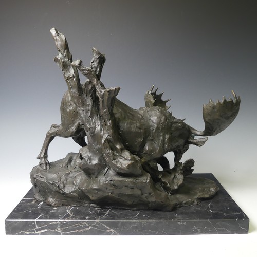 174 - A bronze sculpture of a Moose, modelled walking over rocky terrain, raised on a veined marble base, ... 