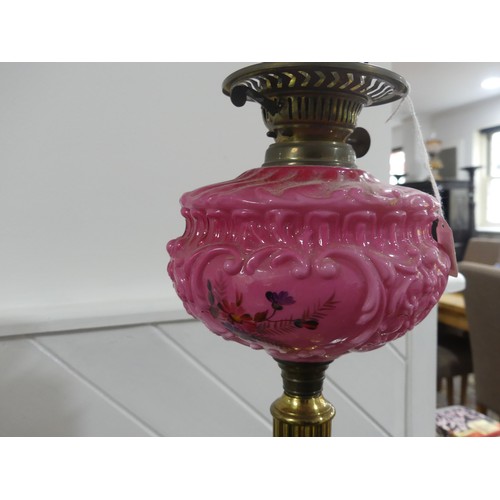 301 - A Victorian brass column Duplex Oil Lamp, having a painted opaque pink font and Duplex burner, raise... 