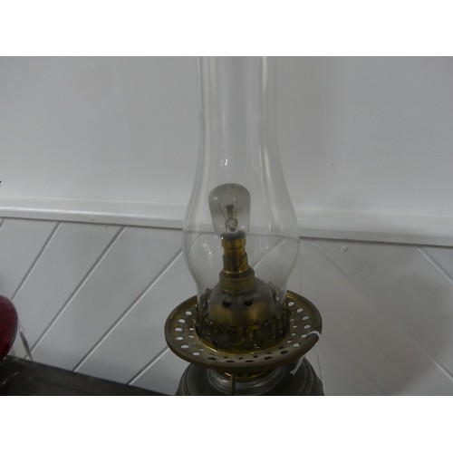 301 - A Victorian brass column Duplex Oil Lamp, having a painted opaque pink font and Duplex burner, raise... 