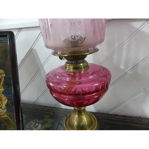 307 - A Victorian brass and cut glass Oil Lamp, having a cut cranberry glass font and etched glass shade, ... 