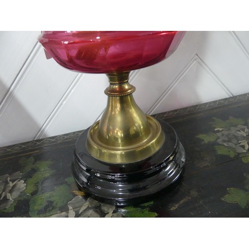 307 - A Victorian brass and cut glass Oil Lamp, having a cut cranberry glass font and etched glass shade, ... 