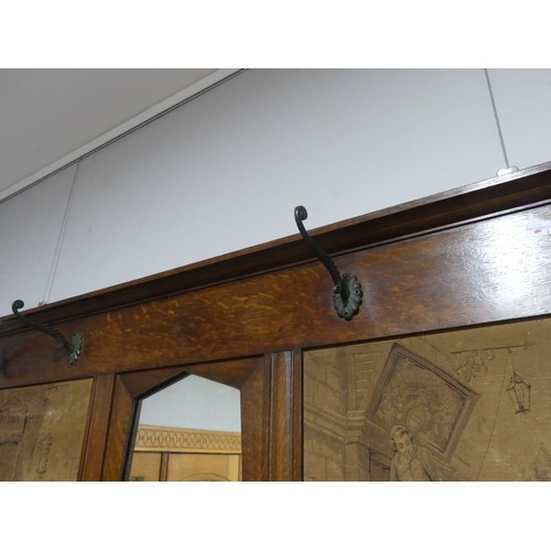 398 - An early 20thC Arts and crafts style oak Hall Mirror with hooks and tapestry panels, W 125cm x H 80c... 