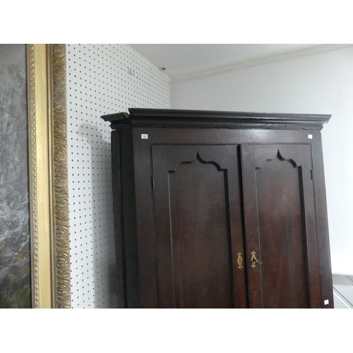 451 - A 19thC oak Corner Cupboard, panelled doors opening to reveal three shaped shelves, above brush slid... 