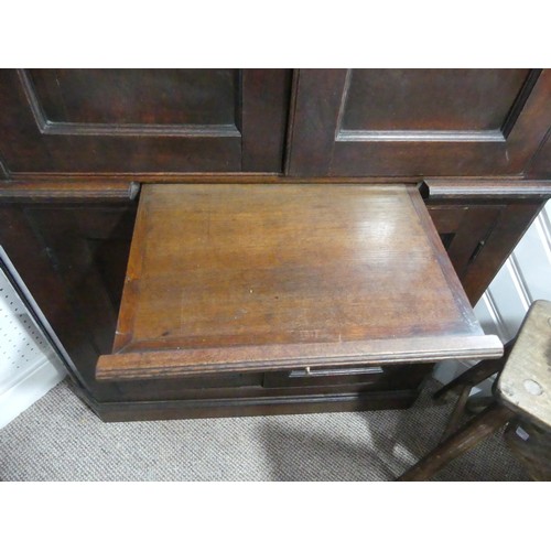 451 - A 19thC oak Corner Cupboard, panelled doors opening to reveal three shaped shelves, above brush slid... 