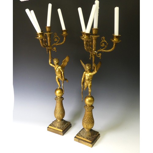 468 - A pair of late 19th century French gilt metal four branch figural Candelabra, the central cupid figu... 