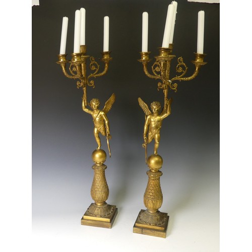 468 - A pair of late 19th century French gilt metal four branch figural Candelabra, the central cupid figu... 