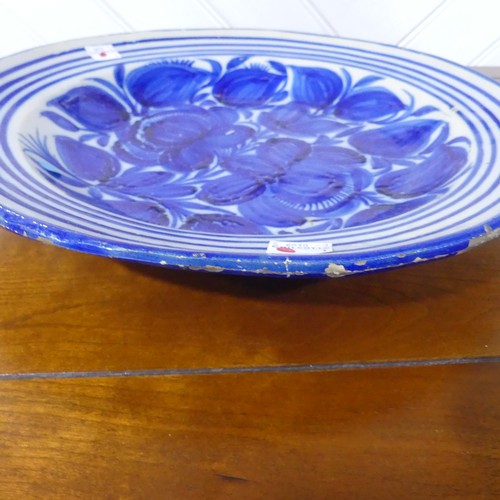 67 - A 19thC North European earthenware Charger, with blue and white decoration, chipped glaze around rim... 